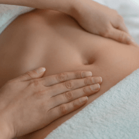 Persona recibiendo un masaje de drenaje linfático en el abdomen