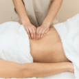 Masaje Reductor – Moldea tu Silueta Terapista aplicando un masaje reductor en el abdomen.